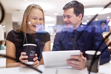 Image showing Woman laughs as man shows tablet