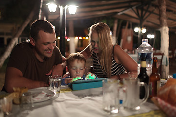 Image showing Parents and child with tablet PC in outdoor cafe