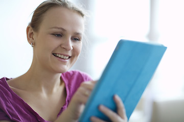 Image showing Young woman smiling as she surfs the internet