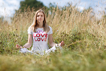 Image showing Young girl meditating in the field