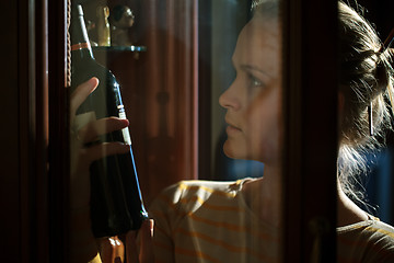 Image showing Woman picking out wine bottle