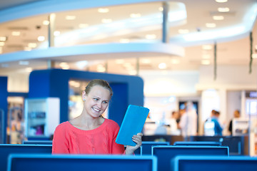 Image showing Woman sitting in a waiting room reading tablet