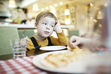 Image showing Bored little boy in a restaurant