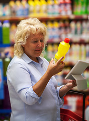 Image showing Senior woman with pad reading the detergent label