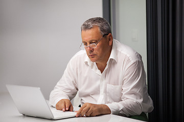 Image showing Senior businessman working with laptop in office