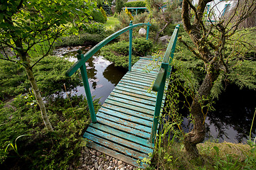 Image showing small green footbridge over a pond