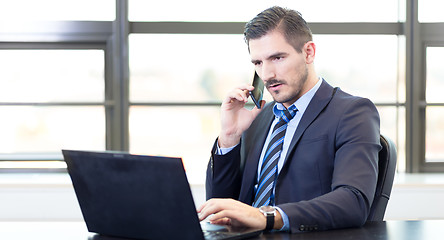 Image showing Businessman in office working on laptop computer.