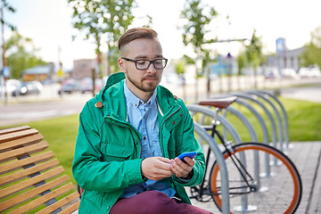 Image showing happy young hipster man with smartphone and bike