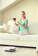 Image showing happy woman with smartphone drinking tea at home