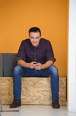 Image showing man in crative box working on smart phone