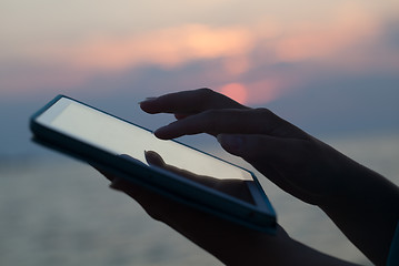 Image showing Woman hands typing on pad outdoor at sunset