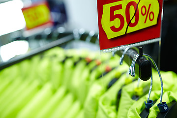 Image showing Sport and casual clothes on hangers in the shop.