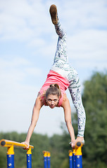 Image showing Agile young gymnast balancing on cross bars