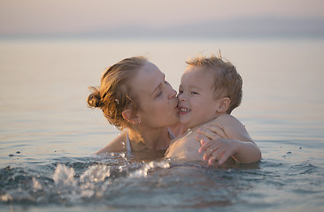 Image showing Mother playing in the sea with her little son