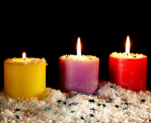 Image showing Three candles with artificial snow.