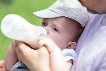 Image showing Man bottle feeding baby