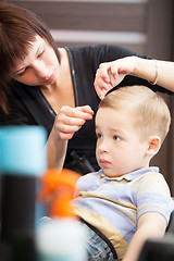Image showing Hairdresser finishing boys haircut with hair setting