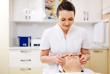 Image showing Professional beautician during the seance of facial massage