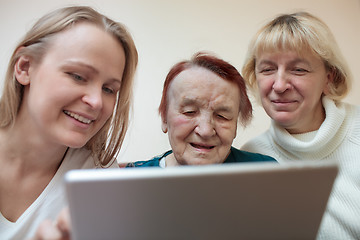 Image showing Three women using a smart tablet