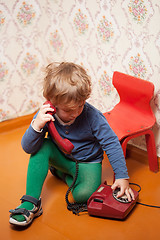 Image showing Young boy using red phone