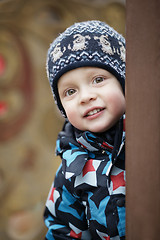 Image showing Cute little boy peering around a door