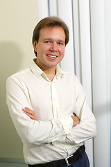 Image showing Happy young man with folded arms indoor