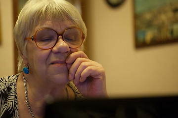 Image showing Thoughtful senior woman reading a computer screen