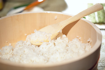 Image showing Cooking sushi. Mixing rice in a wooden plate.