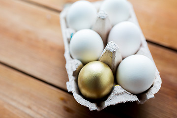 Image showing close up of white and gold eggs in egg box