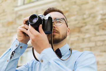 Image showing young hipster man with film camera in city