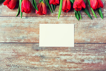 Image showing close up of red tulips and blank paper or letter