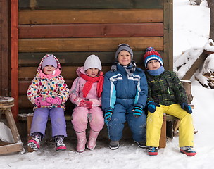 Image showing little children group sitting  together  in front of wooden cabi