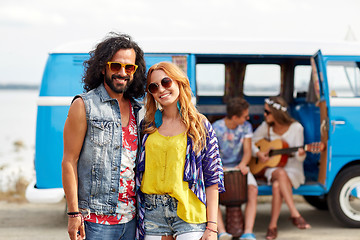 Image showing smiling hippie couple with friends over minivan