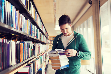 Image showing happy student or man with book in library