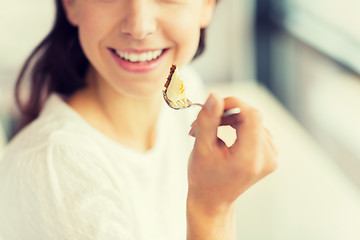 Image showing close up of woman eating cake at cafe or home