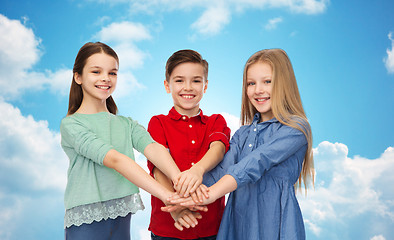 Image showing happy children with hands on top over blue sky