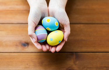 Image showing close up of woman hands with colored easter eggs