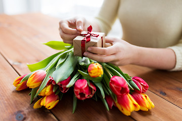 Image showing close up of woman with gift box and tulip flowers