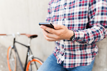 Image showing close up of hipster man with smartphone and bike