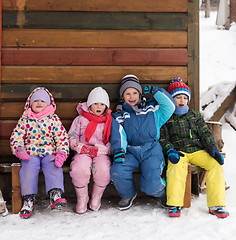 Image showing little children group sitting  together  in front of wooden cabi