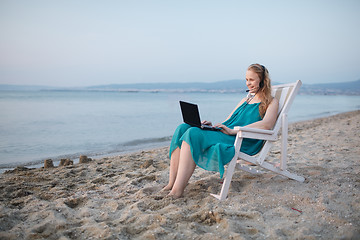 Image showing Woman talking skype at the beach