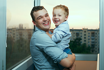 Image showing Young father and son smiling on the balcony.