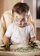 Image showing Creative little boy playing with finger paint