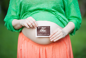 Image showing Pregnant woman with ultrasound image of a baby