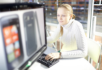 Image showing Young girl is choosing the smart phone.