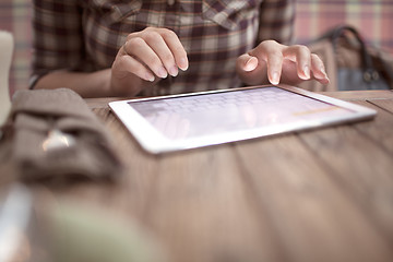 Image showing Woman in cafe typing on touch pad