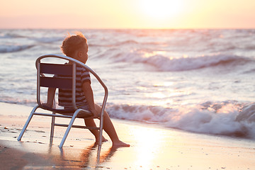 Image showing Boy sitting on the chair by sea