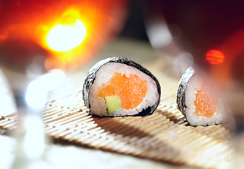 Image showing Sushi rolls and plum wine.