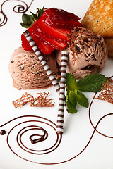 Image showing Chocolate ice cream topped with fresh strawberries