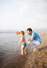 Image showing Young father playing with his son at the beach